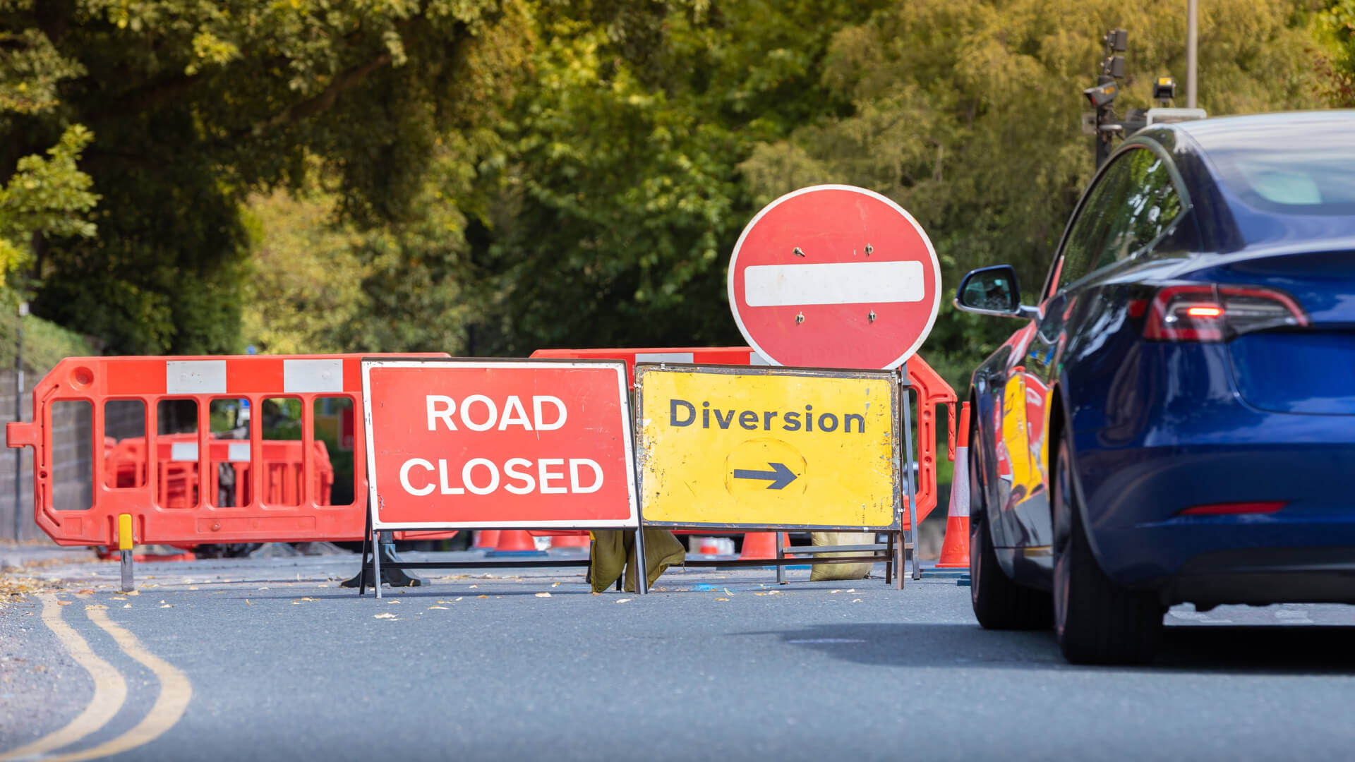 A car stopped at a road closure on a UK road.